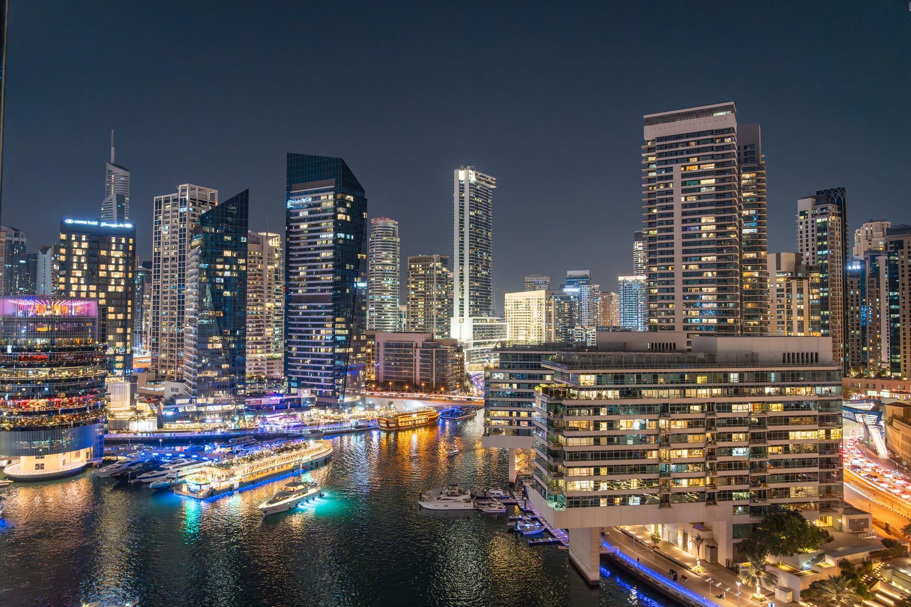 Dubai Marina at night, towers lit above the water