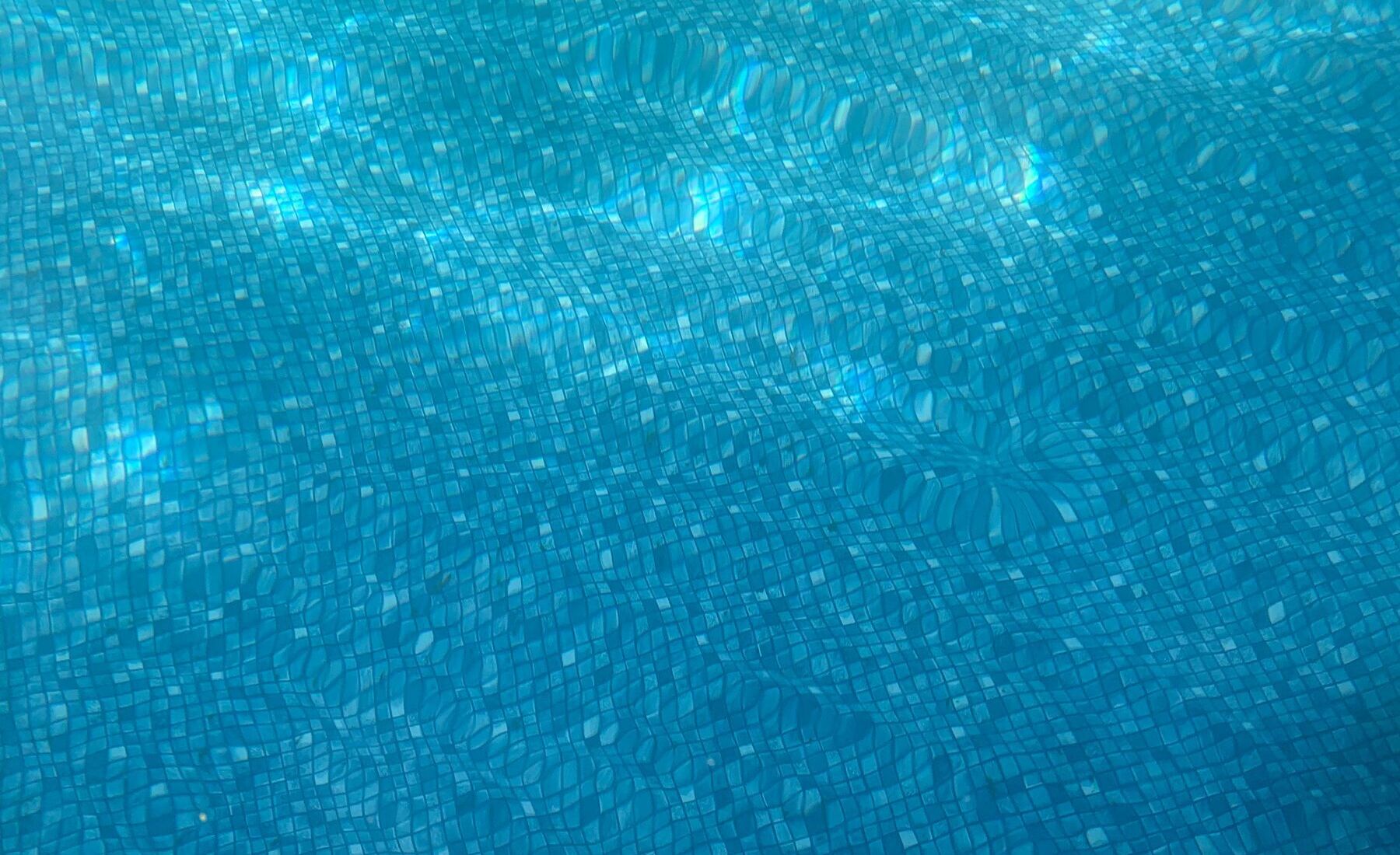 Sunlight moving across the mosaic floor of a swimming pool