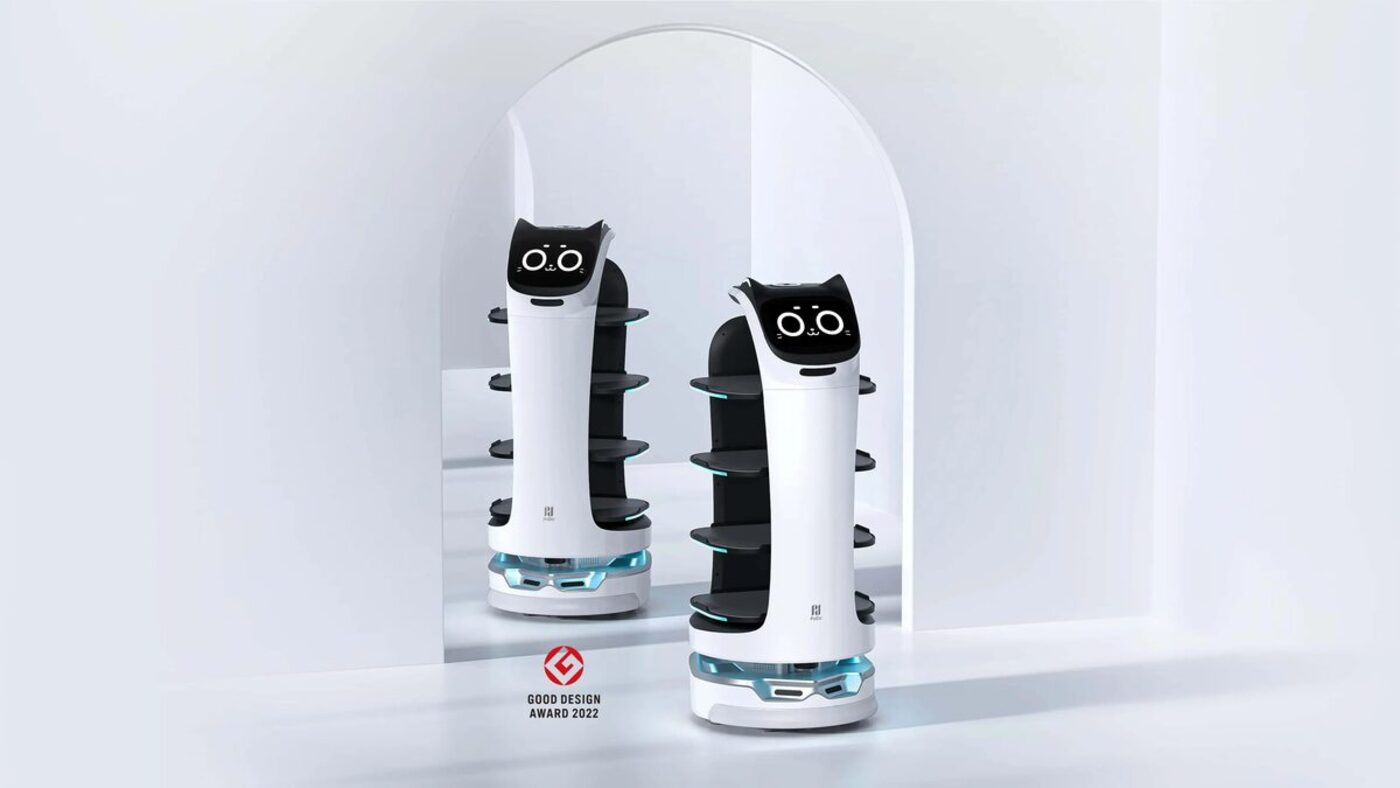 Two Pudu BellaBot service robots with four trays each and a cat face display