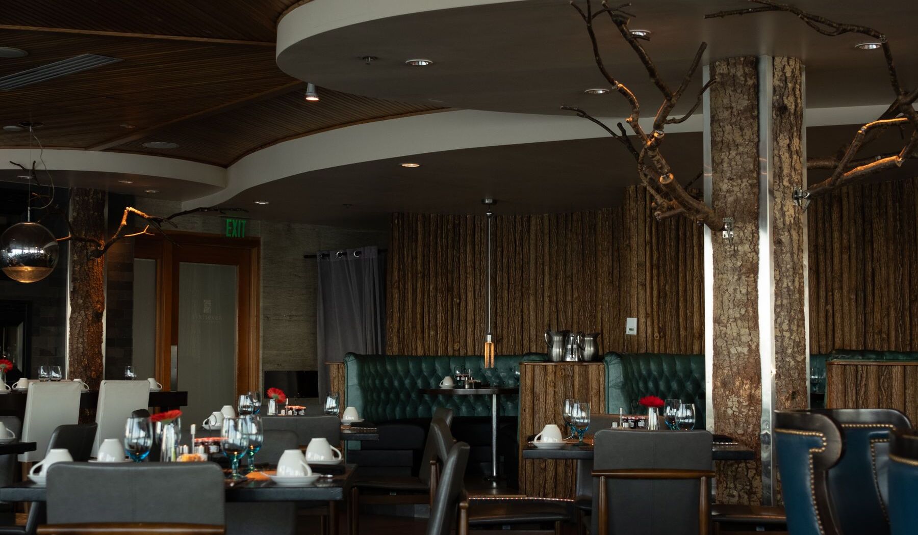Empty dining room of a restaurant, tables set under low lighting